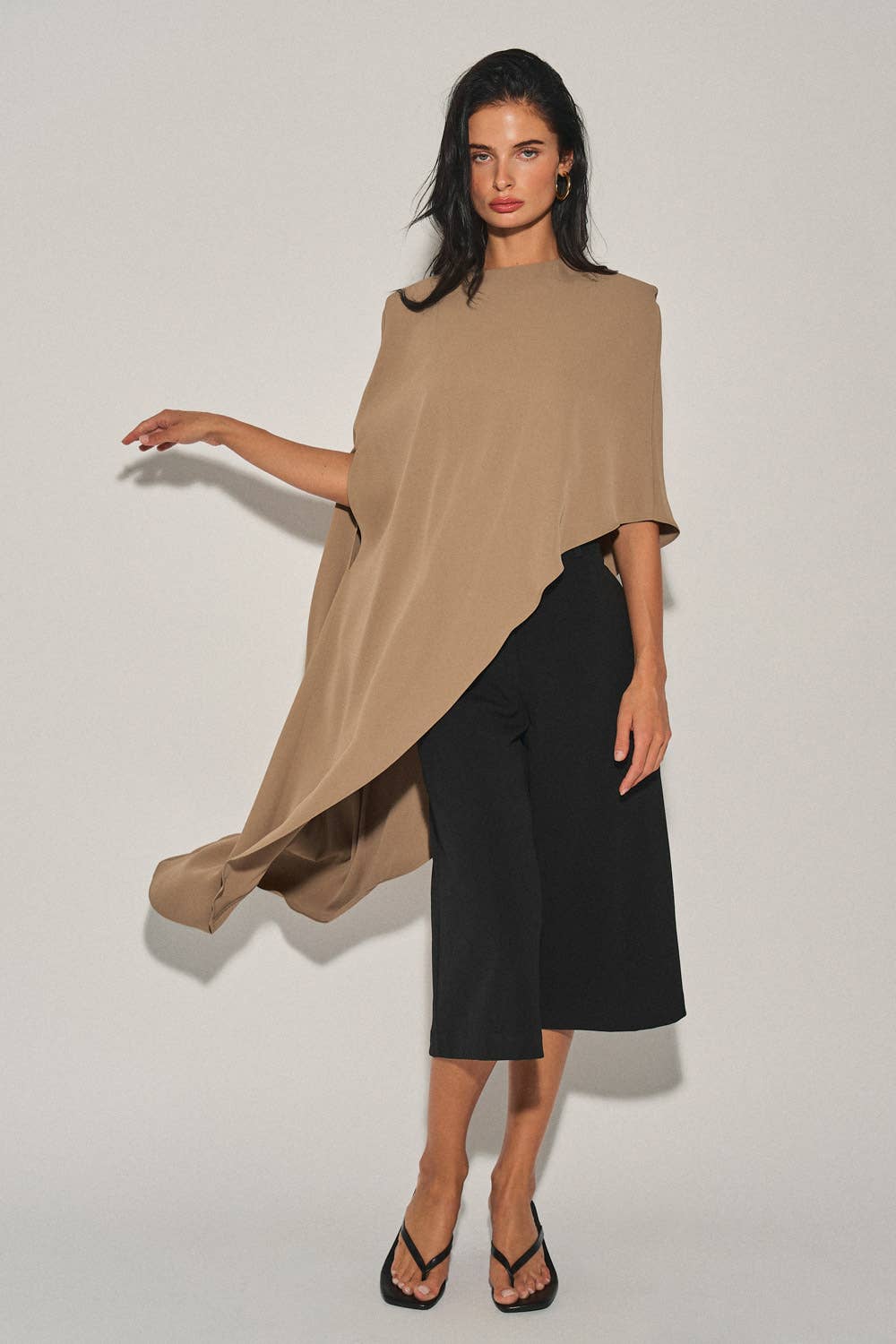 Model wearing Saguaro’s sculptural tan cape top
